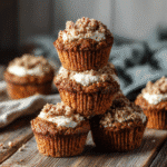 Gluten free carrot cake muffins stacked with cream cheese and streusel